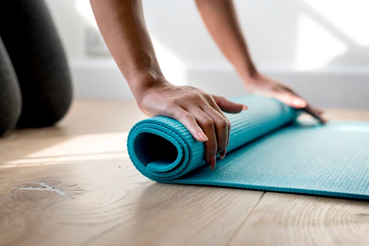 A person rolling up a yoga mat