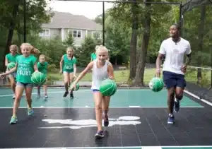 Boston Celtics player dribbling with kids